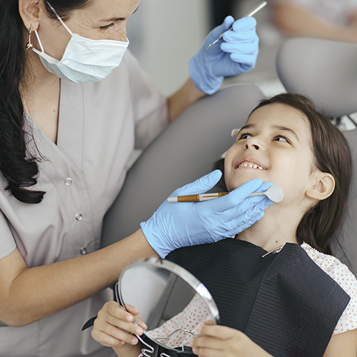 Dentista trabajando con niña